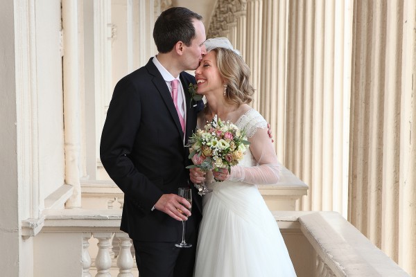 documentary wedding photography newly married bride and groom kiss and snuggle at The Institute of Contemporary Arts in London England UK